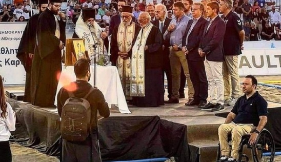 Image: Αλγεινή εικόνα: Επίσημοι και ιερείς σε εξέδρα - Ο πρόεδρος της Παραολυμπιακής Επιτροπής μόνος